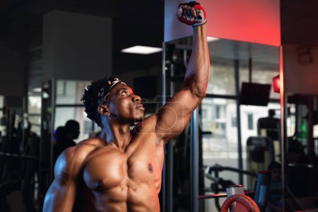 Foto de Retrato de un hombre negro musculoso con un puño hinchado en el gimnasio - Imagen libre de derechos