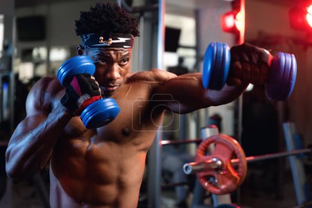 Photo for Portrait of a 20s black muscular male fist working out with dumbbells - Royalty Free Image