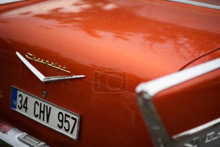 Foto de Izmir, Turquía - 3 de junio de 2023: Primer plano del logotipo de Chevrolet moteado por la lluvia en el maletero de un Chevrolet naranja de 1957 en el IZKOD Classic Car Meet in Buca Pond, Izmir. - Imagen libre de derechos