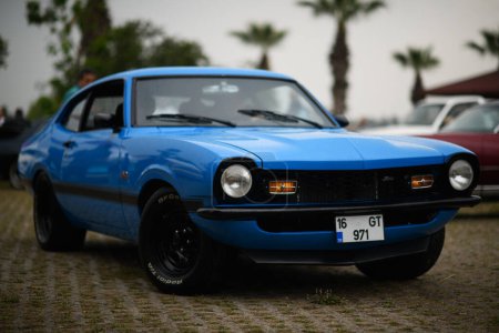 Téléchargez les photos : Izmir, Turquie - 3 juin 2023 : Ford Maverick 1971 bleu trempé de pluie à l'IZKOD Classic Car Meet à Buca Pond, Izmir. - en image libre de droit