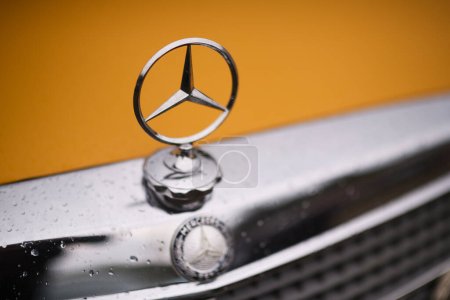 Téléchargez les photos : Izmir, Turquie - 3 juin 2023 : Gros plan sur l'emblème d'une Mercedes-Benz classique jaune lors de l'IZKOD Classic Car Meet à Buca Pond, Izmir - en image libre de droit