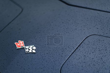 Photo for Izmir, Turkey - June 3, 2023: Close-up shot of the logo on a black 1973 Corvette, covered with raindrops, at the IZKOD Classic Car Meet at Buca Pond - Royalty Free Image