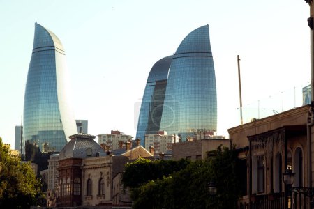 Photo for Baku, Azerbaijan - June 25, 2023: A sunset view showcasing the contrast between the historic buildings of Icheri Sheher and the modern Flame Towers - Royalty Free Image