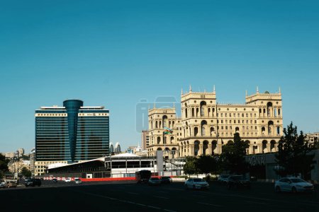 Foto de Bakú, Azerbaiyán - 26 de junio de 2023: Una imagen impactante capturada al amanecer con la histórica Casa de Gobierno junto al contemporáneo Hilton Hotel, que presenta una mezcla de lo antiguo y lo nuevo. - Imagen libre de derechos