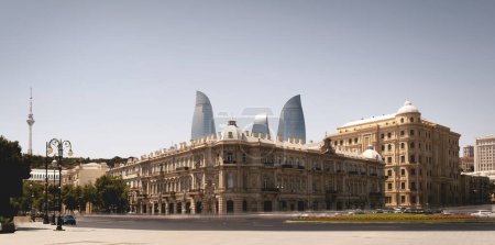 Photo for Baku, Azerbaijan - June 26, 2023: This striking photograph showcases the historic SOCAR office building with the modern Flame Towers towering above it. Captured during the daytime, this long-exposure shot reveals the architectural contrasts that defi - Royalty Free Image