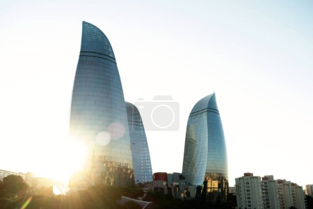 Téléchargez les photos : Baku, Azerbaijan - June 26, 2023: An evening shot of the Flame Towers, iconic landmarks of Baku, with the sunlight piercing through them, creating a beautiful and dramatic effect. - en image libre de droit