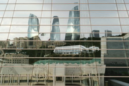 Photo for Baku, Azerbaijan - June 28, 2023: On a cloudy morning, the iconic Flame Towers cast their shimmering reflection onto the windows of a nearby shopping center, creating a mesmerizing and artistic view. - Royalty Free Image