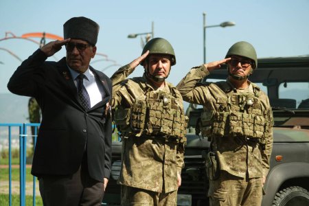 Foto de Izmir, Turquía - 30 de agosto de 2023: En la Plaza de la República durante las celebraciones del Día de la Victoria, un orgulloso veterano de la guerra turca, flanqueado por dos soldados, saluda frente a un camión militar, encarnando el honor y el respeto. - Imagen libre de derechos