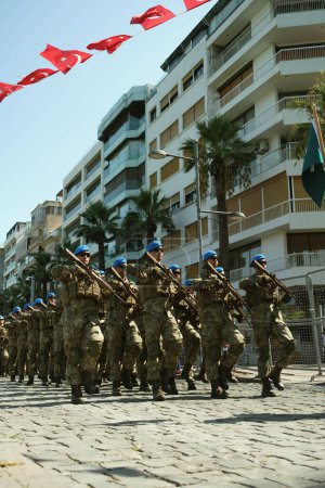 Foto de Izmir, Turquía - 30 de agosto de 2023: Soldados en uniformes de camuflaje marchan en formación contra un telón de fondo de edificios de apartamentos durante el desfile del Día de la Victoria. - Imagen libre de derechos