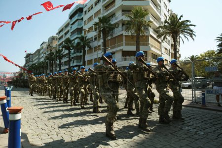 Foto de Izmir, Turquía - 30 de agosto de 2023: Soldados en uniformes de camuflaje marchan en formación contra un telón de fondo de edificios de apartamentos durante el desfile del Día de la Victoria. - Imagen libre de derechos