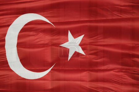 Foto de Una fotografía que captura el vibrante rojo y blanco de la bandera turca, simbolizando la unidad y la independencia, mientras ondea con gracia contra un cielo despejado. - Imagen libre de derechos