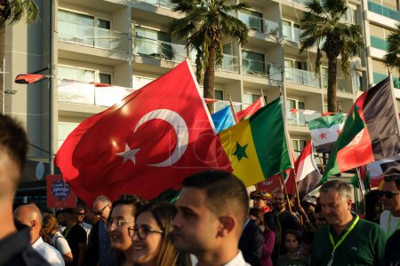 Foto de Izmir, Turquía - 1 de septiembre de 2023: Durante la procesión inaugural de la Feria Internacional de Izmir, una multitud camina a lo largo del Kordon, sosteniendo banderas de varios países, celebrando el inicio del evento cultural - Imagen libre de derechos