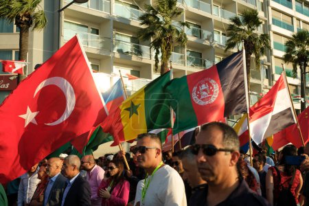 Téléchargez les photos : Izmir, Turquie - 1er septembre 2023 : Au cours de la procession d'ouverture de la Foire internationale d'Izmir, une foule marche le long du Kordon, tenant des drapeaux de divers pays, célébrant le début de l'événement culturel - en image libre de droit
