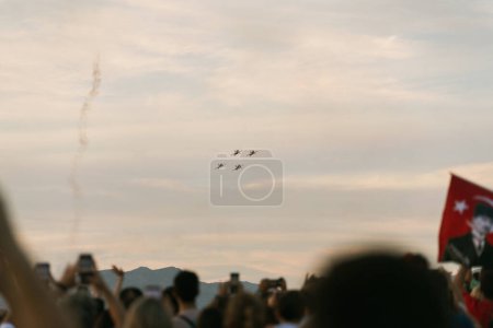 Téléchargez les photos : Izmir (Turquie), le 9 septembre 2023, l'équipe de vol des Turkish Stars montre leur maîtrise aérienne alors qu'ils traversent le ciel. Sous eux, une foule floue de spectateurs regarde avec crainte, capturant l'essence des célébrations du Jour de la Libération - en image libre de droit