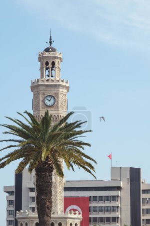 Photo for Izmir, Turkey, A picturesque view of the renowned Izmir Clock Tower, standing tall against the sky, complemented by a palm tree in the foreground, adding a touch of nature to the historic landmark - Royalty Free Image