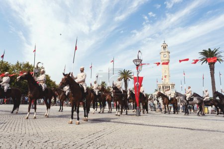 Foto de Izmir, Turquía, 9 de septiembre de 2023, Caballeros exhiben orgullosamente sus habilidades ecuestres frente a la icónica Torre del Reloj Izmir, que simboliza la liberación de la ciudad. Hacen una pose, celebrando el significado histórico del día - Imagen libre de derechos