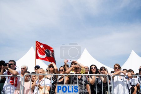 Téléchargez les photos : Izmir (Turquie), le 9 septembre 2023 : Une foule se tient derrière une barricade de la police, tenant les drapeaux turcs hauts alors qu'ils observent avec enthousiasme les cérémonies marquant la libération d'Izmir - en image libre de droit