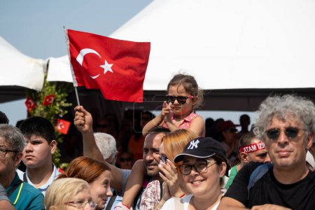 Foto de Izmir, Turquía, 9 de septiembre de 2023: Un momento conmovedor capturar a una niña de 8-9 años con gafas de sol, posada sobre los hombros de su padre, ondeando la bandera turca con orgullo durante las ceremonias de liberación de Izmir - Imagen libre de derechos