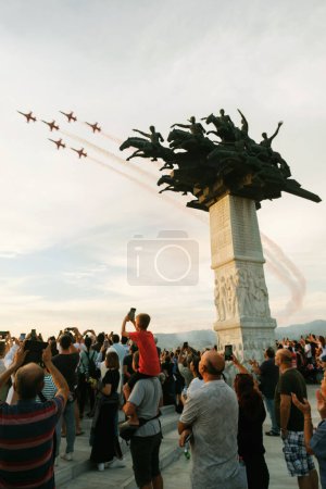Photo for Izmir, Turkey, September 9, 2023: The acclaimed Turkish Stars fighter jets soar past the iconic Republic Tree Monument while an enthralled crowd captures the breathtaking display on their smartphones, immortalizing a moment of national pride - Royalty Free Image