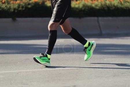 Téléchargez les photos : Izmir, Turquie, 10 septembre 2023 : Gros plan des pieds d'un coureur, short Nike noir et chaussures de course Nike vertes, au milieu du demi-marathon d'Izmir - en image libre de droit