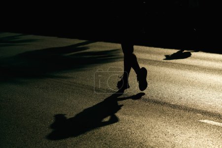 Téléchargez les photos : Izmir, Turquie, 10 septembre 2023 : Les coureurs deviennent des silhouettes contre la lumière du soleil sur l'asphalte pendant le marathon d'Izmir - en image libre de droit
