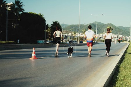Foto de Izmir, Turquía, 10 de septiembre de 2023: En la Maratón de Izmir, dos mujeres, una con un perro y un hombre compiten, agregando un toque único a la carrera - Imagen libre de derechos