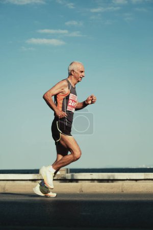 Téléchargez les photos : Izmir, Turquie, 10 septembre 2023 : Un coureur senior, âgé de 70 ans, chaussure Nike, est capturé à mi-chemin, montrant sa vitalité au marathon d'Izmir - en image libre de droit