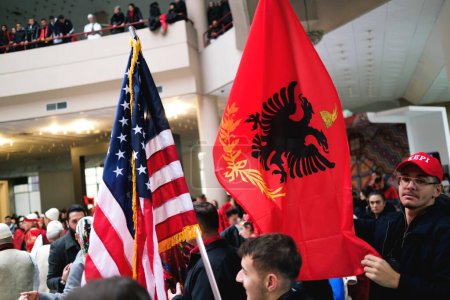 Téléchargez les photos : Tirana, Albanie - 28 novembre : Danse traditionnelle albanaise avec des drapeaux albanais et américains, près de la statue de Mère Teresa au Palais - en image libre de droit