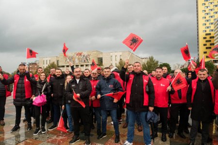 Téléchargez les photos : Tirana, Albanie - 28 novembre 2023 : Sur la place Skanderbeg un jour pluvieux de l'indépendance, nous voyons la foule participer avec enthousiasme aux célébrations, tenant des drapeaux albanais, avec le Musée national d'histoire de Tirana en arrière-plan - en image libre de droit