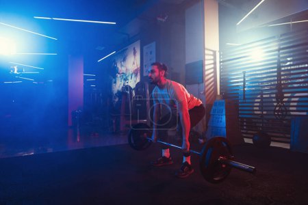 Photo for Athlete perfecting the deadlift in a mystical gym ambiance, with blue and red lighting cutting through the mist - Royalty Free Image