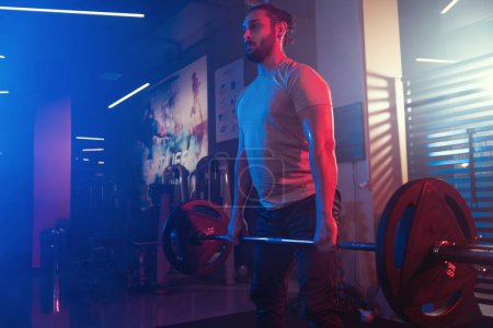 Athlete perfecting the deadlift in a mystical gym ambiance, with blue and red lighting cutting through the mist