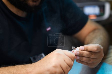 Photo for A dental technician meticulously shapes a prosthetic tooth, ensuring every contour is perfected for a custom fit - Royalty Free Image