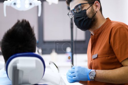 Foto de Un dentista en profunda concentración mientras examina a su paciente, brindando atención experta con una precisión que asegura una sonrisa saludable - Imagen libre de derechos