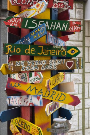 Foto de Una vibrante muestra de letreros hechos a mano que apuntan a varios destinos globales, simbolizando viajes y aventuras. - Imagen libre de derechos