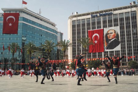 Photo for Izmir, Turkey - April 23, 2024: Children dressed in traditional Zeybek attire perform the iconic dance at Republic Square for the National Sovereignty and Children's Day, with a backdrop of Turkish flags and an Ataturk portrait - Royalty Free Image
