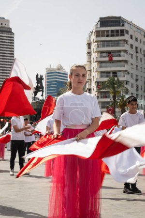 Photo for Izmir, Turkey - April 23, 2024: A close-up view of a young student holding a Turkish flag, with fellow participants waving flags in the background, during the April 23 National Sovereignty and Children's Day celebrations at Izmir's Republic Square - Royalty Free Image