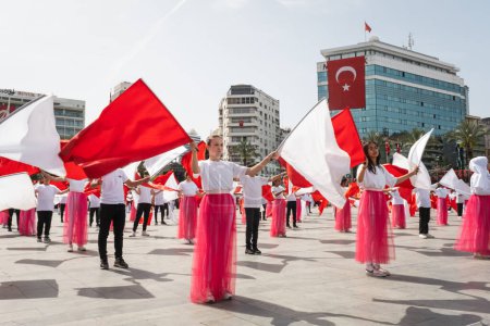 Téléchargez les photos : Izmir, Turquie - 23 avril 2024 : De jeunes étudiants vêtus de rouge et blanc dansent sur la place de la République d'Izmir lors des festivités de la Journée nationale de la souveraineté et de l'enfance en Turquie - en image libre de droit
