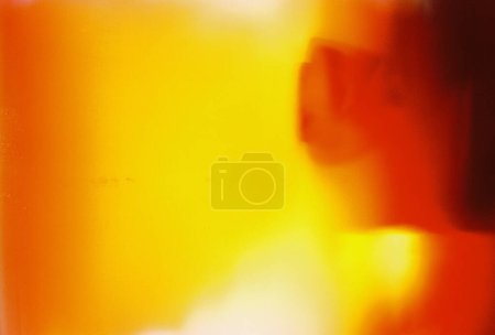 Escaneo de película analógica real con una textura quemada y granulada distintiva, mostrando tonos naranja y amarillo vibrantes.