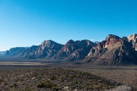 Panoramic shot of the stunning Red Rock Canyon National Conservation Area with desert vegetation and surrounding mountains on a sunny day - Nevada, USA