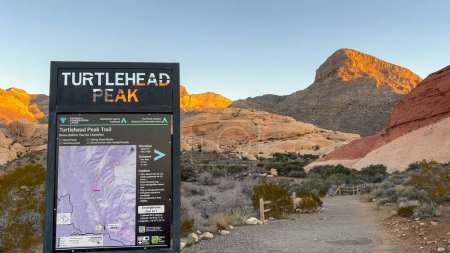 The Turtlehead Peak Trailhead sign and map with stunning glowing mountain view at sunrise - Red Rock Canyon National Conservation Area, Nevada, USA