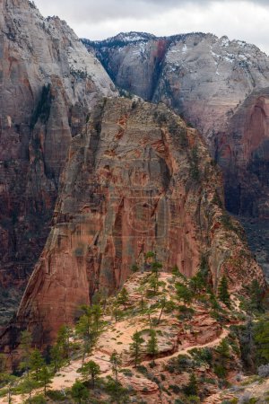 Breathtaking aerial view of the iconic Angels Landing trail and rock formation at Zion National Park in Utah. The landscape features towering cliffs against a backdrop of snowy mountains - Utah, USA