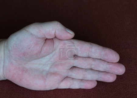 Palm of right hand of an elderly man close-up on background of dark fabric