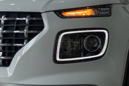 Passenger car headlights switched on close-up