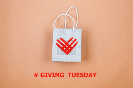 Photo for Red linear paper hearts over grey bag on light beige background. Giving Tuesday, the global day of charity. give help, donations support concept. - Royalty Free Image