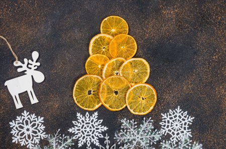 Téléchargez les photos : Oranges sèches faites à la main pour la décoration de Noël. Arbre de Noël composé de tranches d'orange sèches. Concept d'artisanat et de cadeaux maison de vacances, zéro déchet, décor naturel, - en image libre de droit