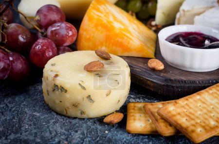 Photo for Assorted homemade pieces cheese with jam, grapes, cookies and nuts, cookies and nuts on table.  Fresh dairy product, cheese snack, healthy organic food. Delicious appetizer. - Royalty Free Image