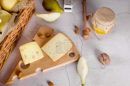 Foto de Surtido sabroso queso de diferentes tipos y tamaños en la mesa. cabezas de queso y trozos en una tabla de madera. Productos lácteos frescos, alimentos orgánicos saludables. Delicioso aperitivo. - Imagen libre de derechos