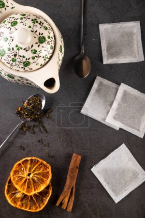 Photo for Tea composition teapot and teacup with tea bags on dark background. Flat lay. Top view. - Royalty Free Image