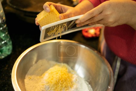 Photo for Woman's Hands Grating Cheese for Cheese Scones Recipe - Royalty Free Image