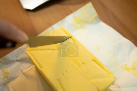 Téléchargez les photos : Girl Cutting Butter, un ingrédient clé pour les scones au fromage - en image libre de droit